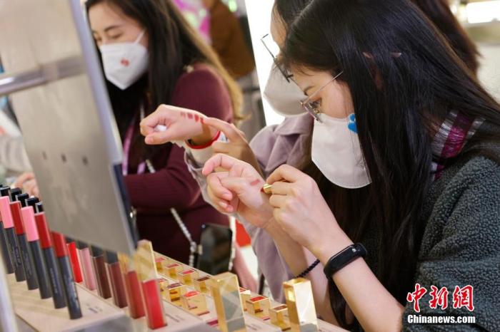 圖為女生正在體驗口紅產(chǎn)品。 殷立勤 攝