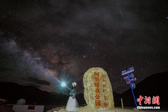 圖為6月20日晚，游客“打卡”西藏阿里暗夜公園，天上是銀河與流星（右上角）。曹枝清 攝