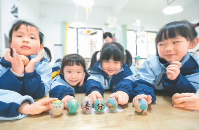3月18日,貴州省黔南布依族苗族自治州都勻市青云湖幼兒園的小朋友們在體驗立蛋民俗。肖 偉攝(人民視覺)