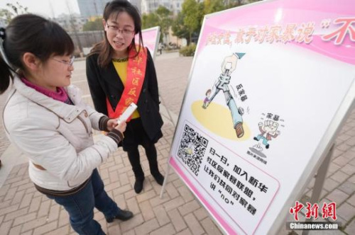 資料圖：今年3月8日，安徽合肥新華社區(qū)志愿者夏一瓊(右)向市民普及反家暴相關(guān)法律知識。鐘欣 攝